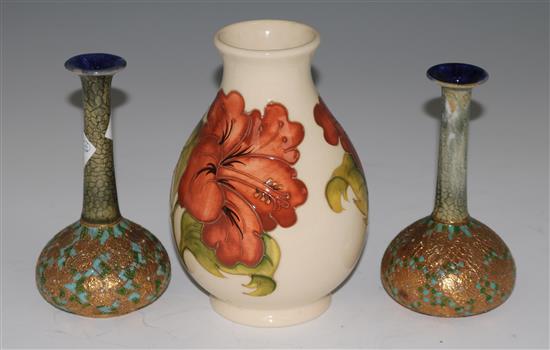 A Moorcroft hibiscus pattern vase, 19cms and a pair of Doulton vases